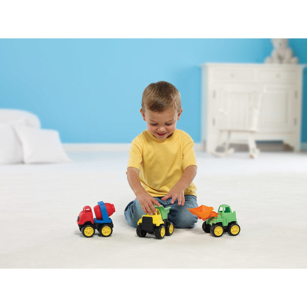 Little Boy Sitting on Floor Playing with Little Tuffies Trucks