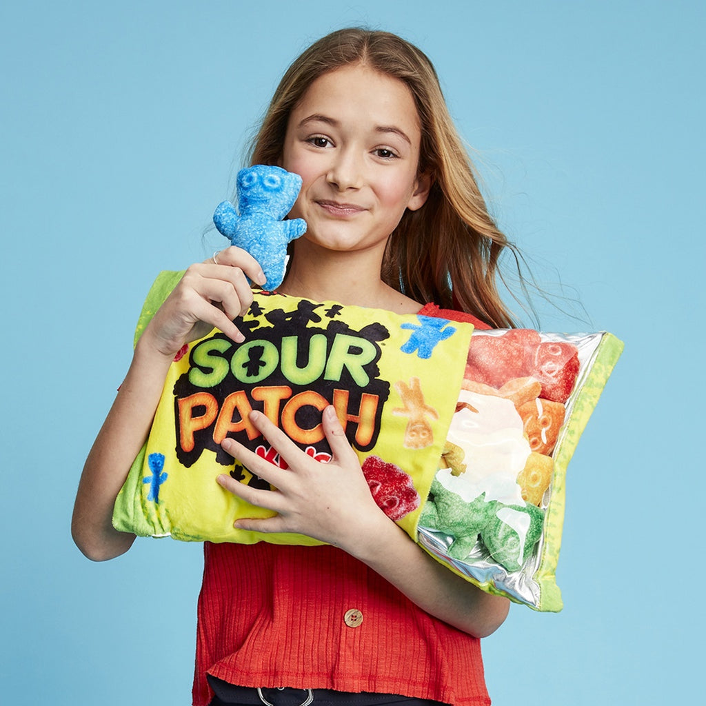 Child holding the contents of Sour Patch Plush and the pillow