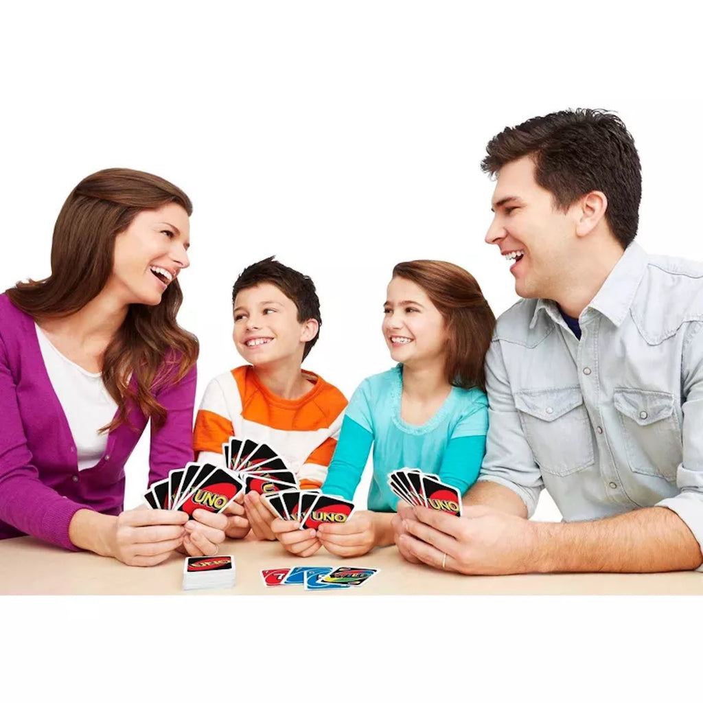 Family playing UNO card game together on a white background