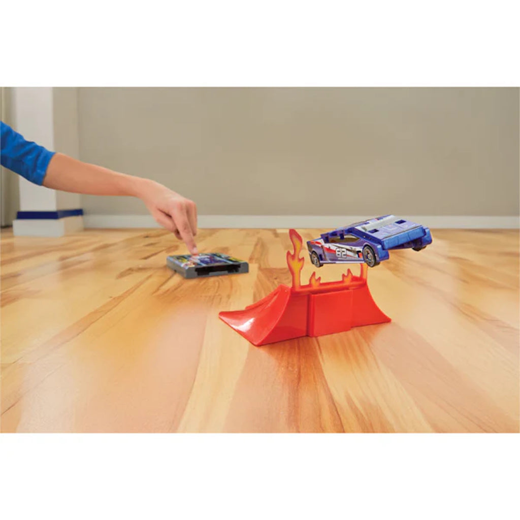 Toy cars and a red ramp on a wooden floor with a neutral background