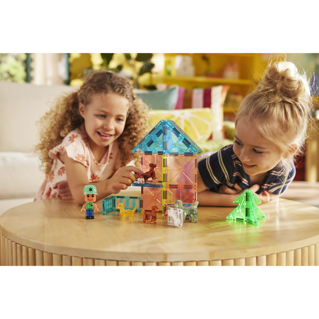 Two children playing with Magna-tiles Puppy Park Set on a wooden table.