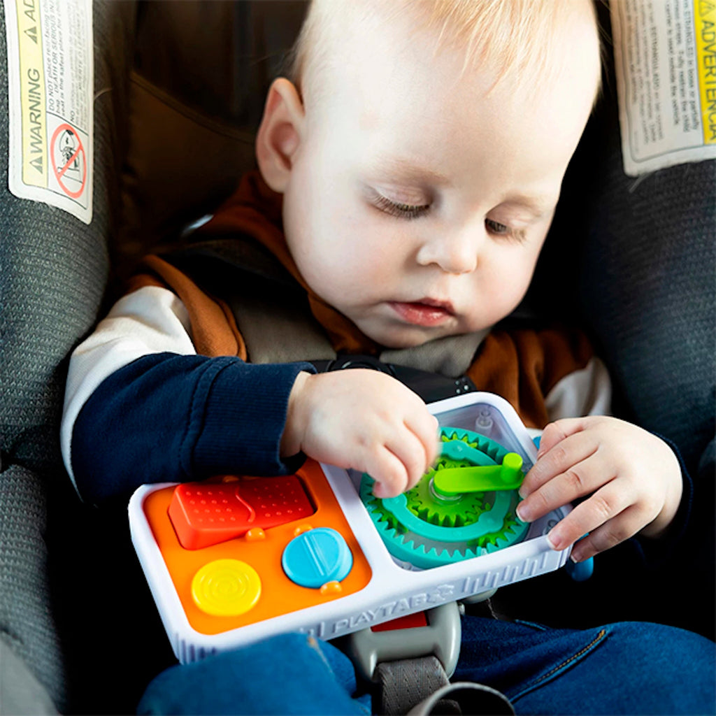 Child playing with Play Tab Go in a car seat