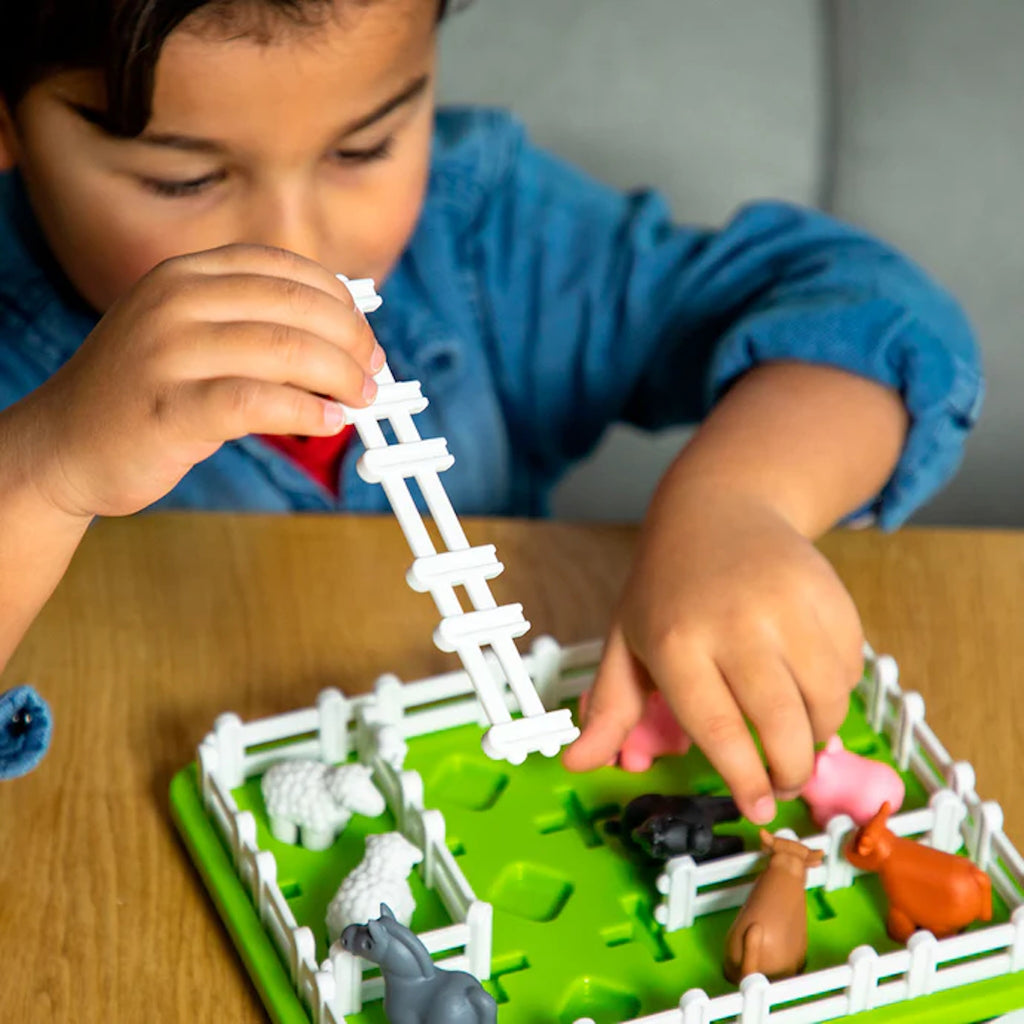 Child playing with Smart Farm game on a wooden table