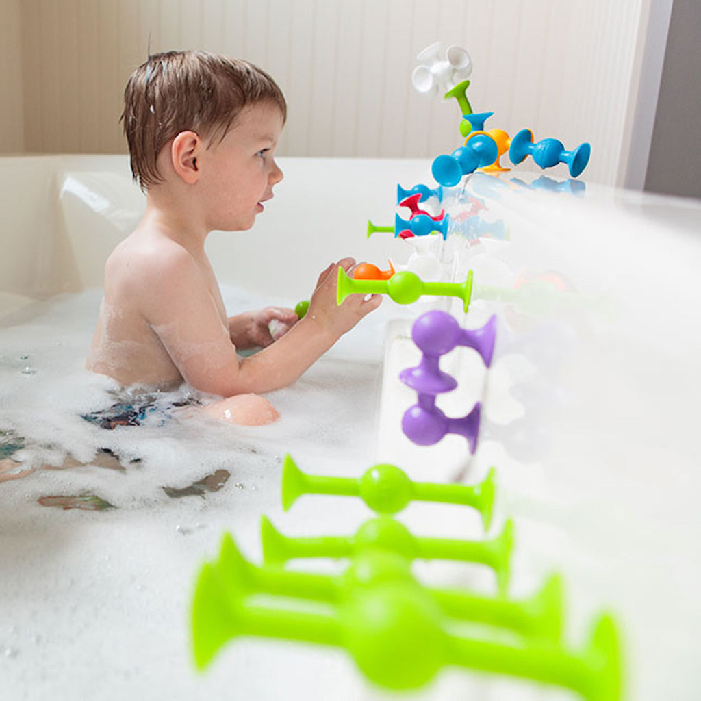 Child playing with Squigz in bath