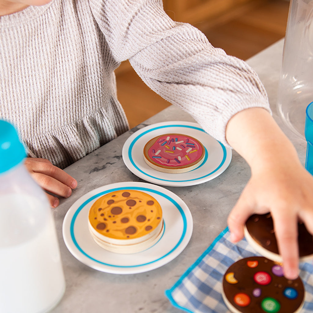 Child playing with cookies in Pretendables Milk and Cookies Set