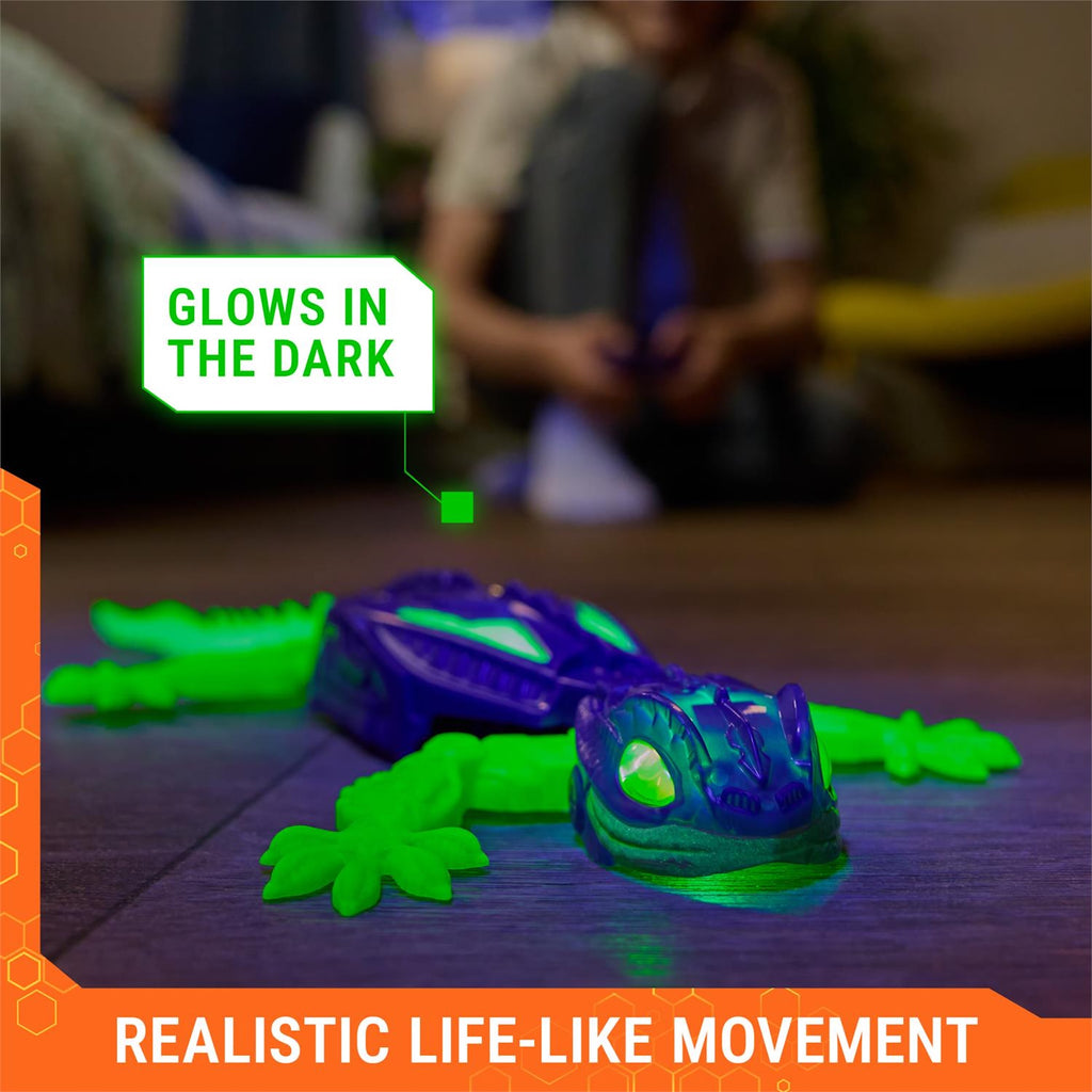 Wall Crawler Gecko with glowing effect on a wooden floor, labeled 'Glowing in the Dark' and 'Realistic Life-Like Movement'.