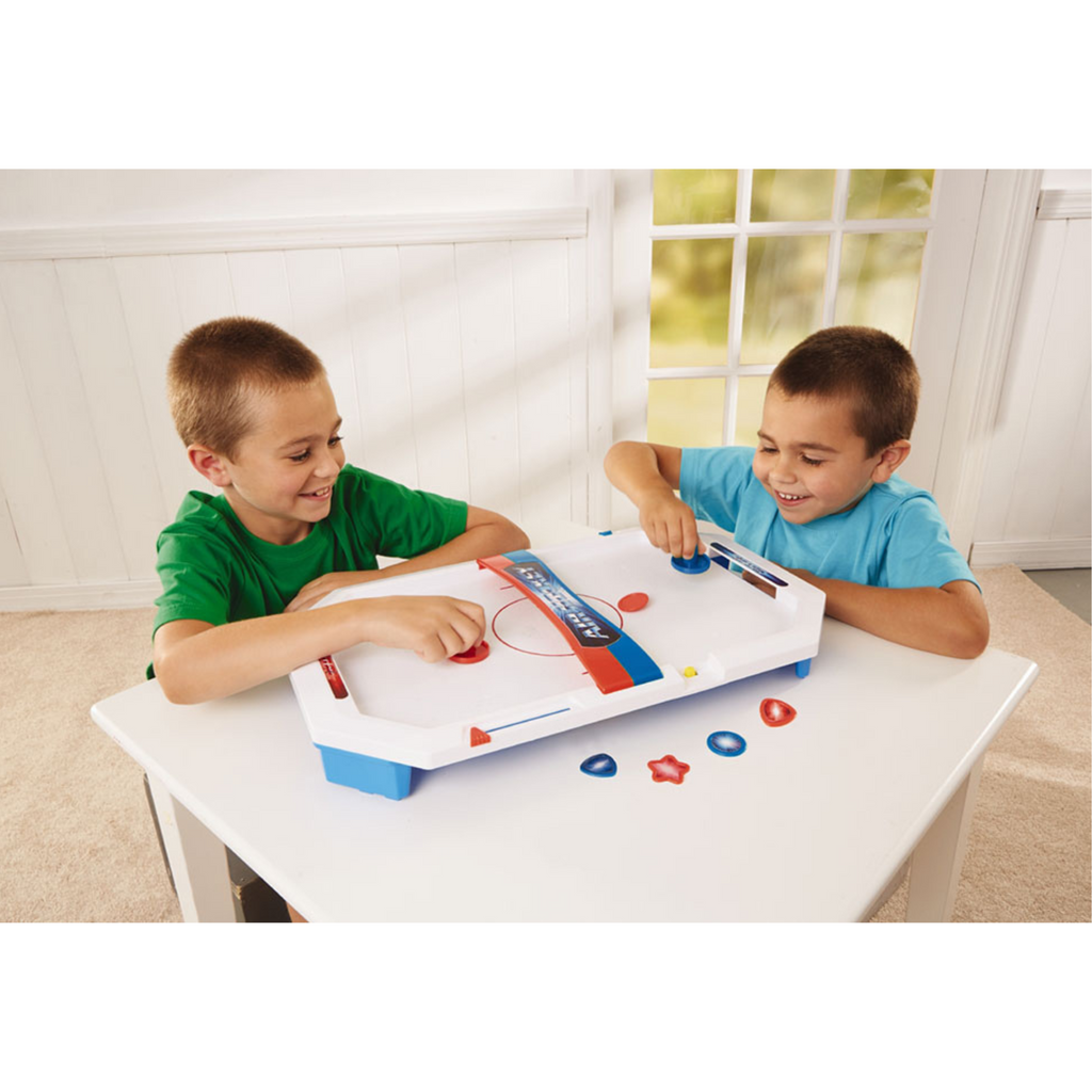 Two children playing Table Top Air Hockey