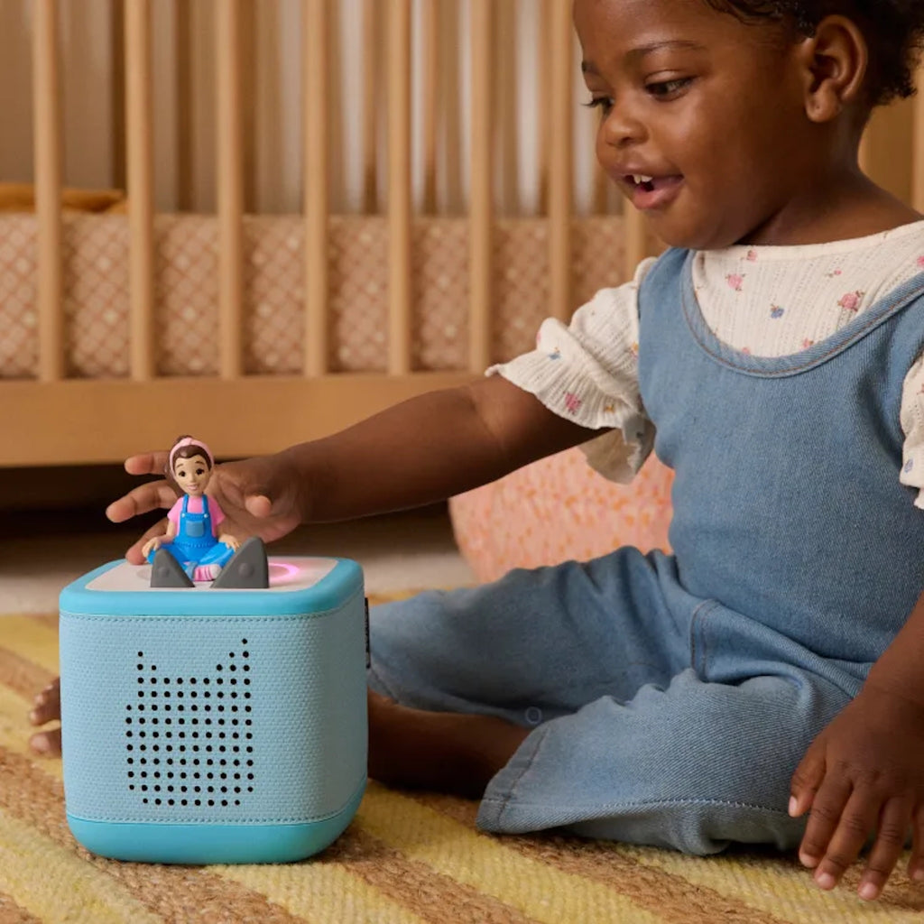 Child playing with a blue Toniebox 2 and Ms Rachel tonie on the floor