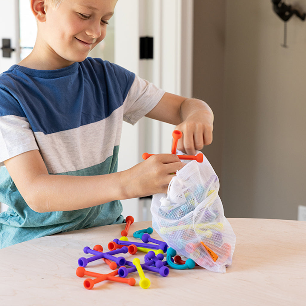 Child putting Plip Kit Pieces in Bag