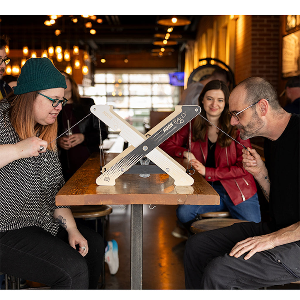 Two people sitting at a table in a restaurant playing Hook Rally