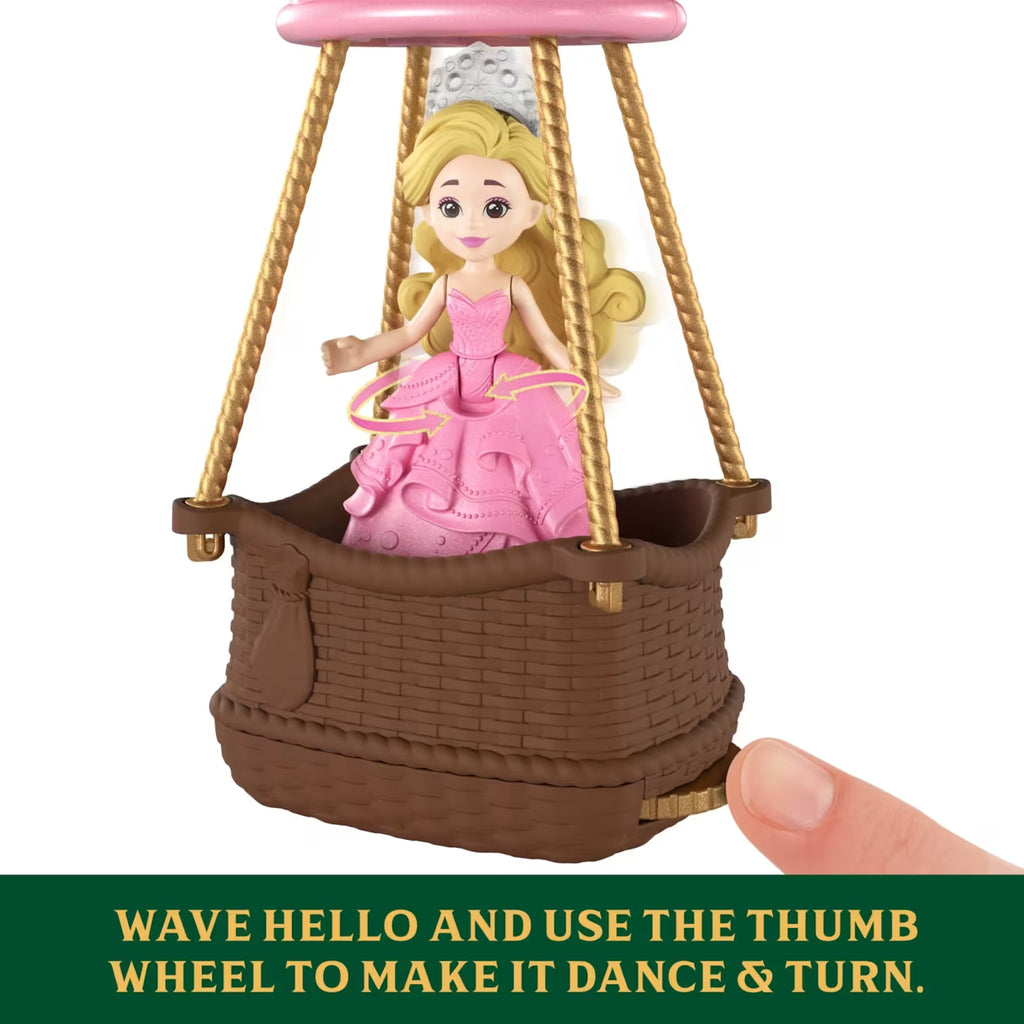 Toy figure of Glinda in a hot air balloon with a hand interacting with it.