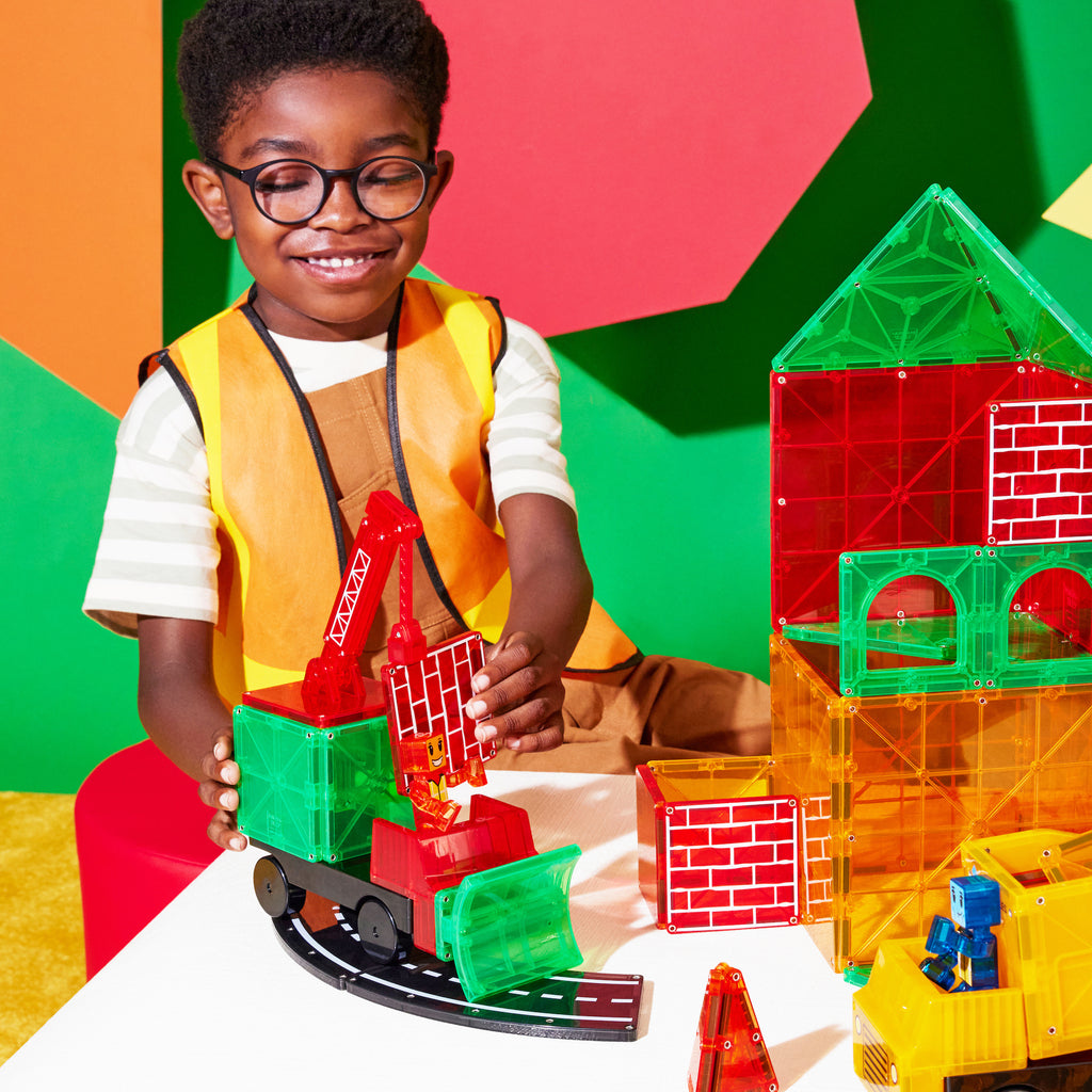 Child playing with Magna-Tiles Builder XL Set wearing a construction vest