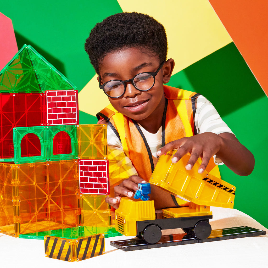 Child playing with Magna-Tiles Builder XL Set wearing a construction vest