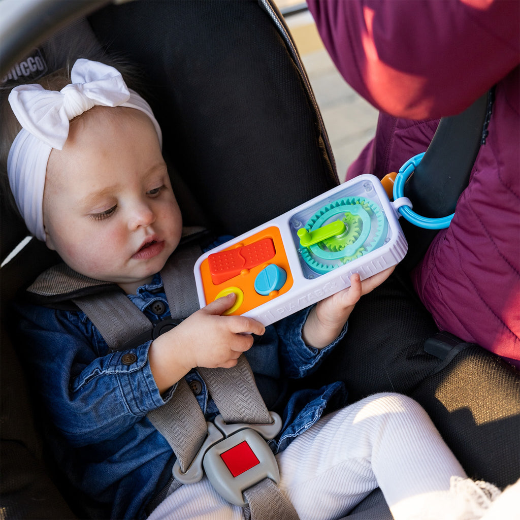 Child in a car seat holding Play Tab Go