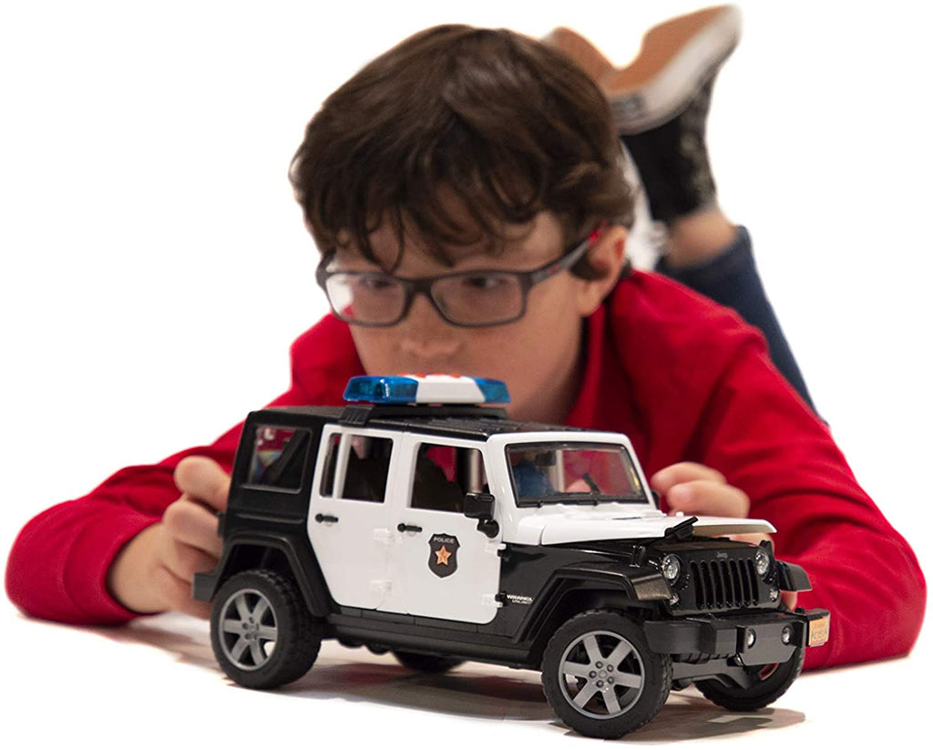 Child Laying Down Playing with Bruder Jeep Rubicon Police Car