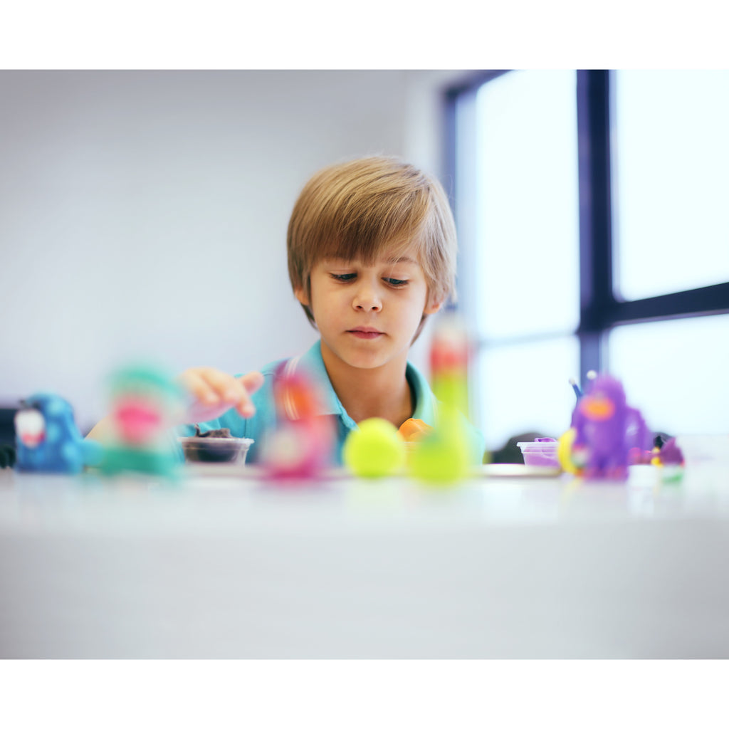 Little Boy Playing with Clay Dinos