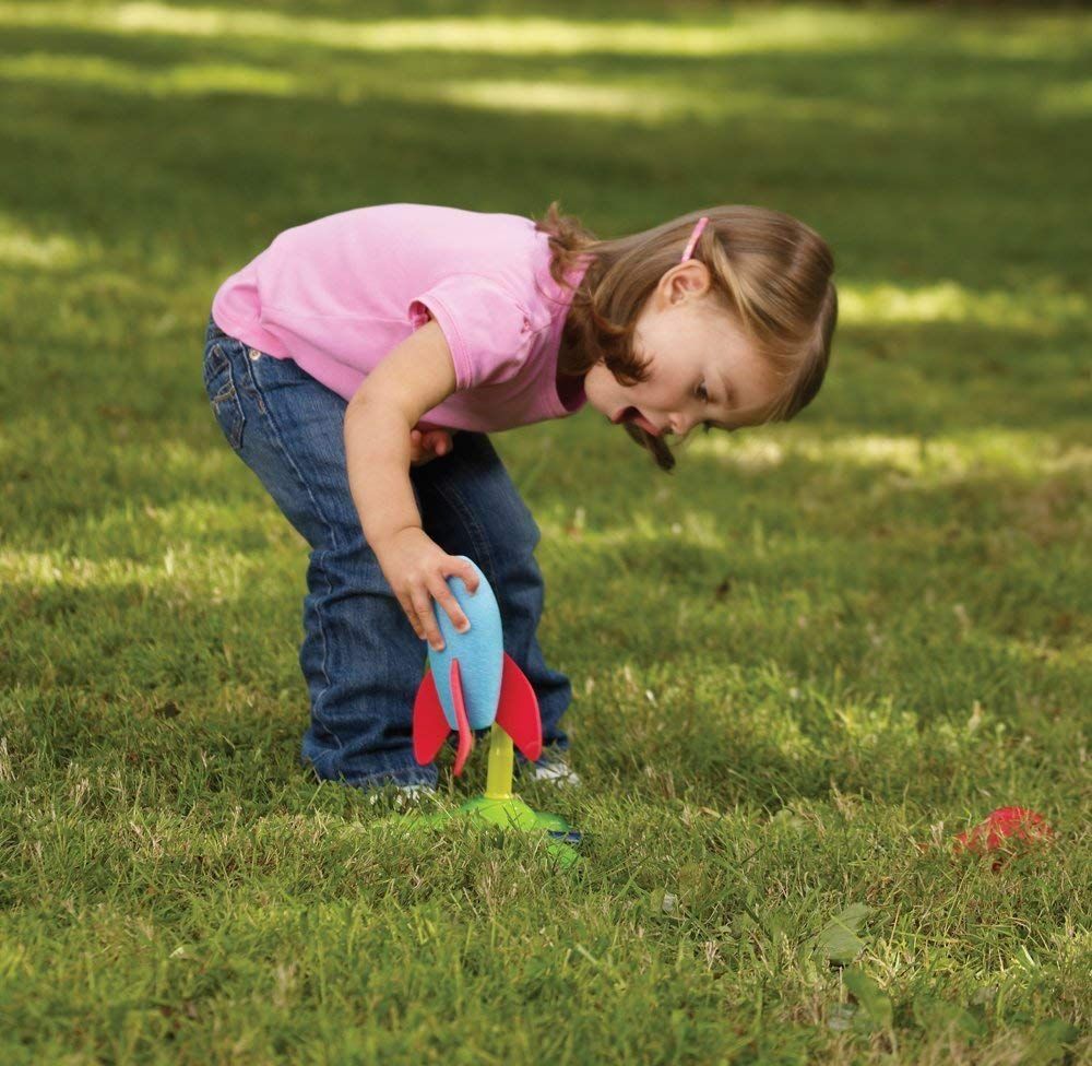 Girl Playing With Rocket Zoomer In Grass