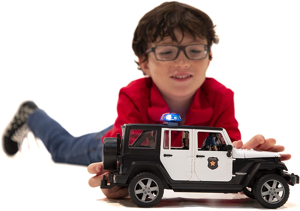 Child Laying Down Playing with Bruder Jeep Rubicon Police Car